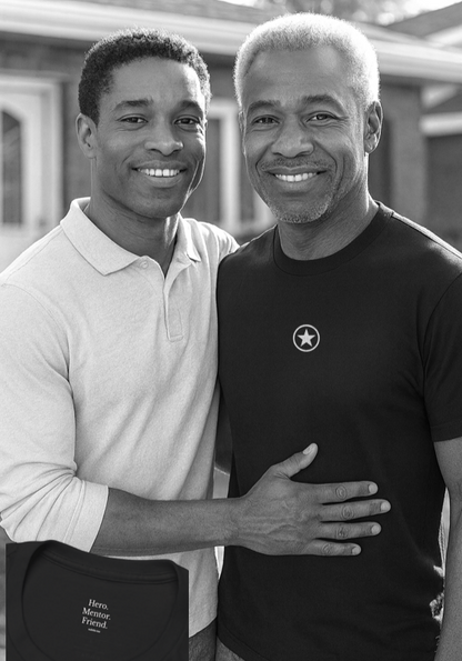 Father and son smiling warmly outside while wearing the Hero Mentor Friend T-shirt, a meaningful gift that honours quiet strength and guidance.